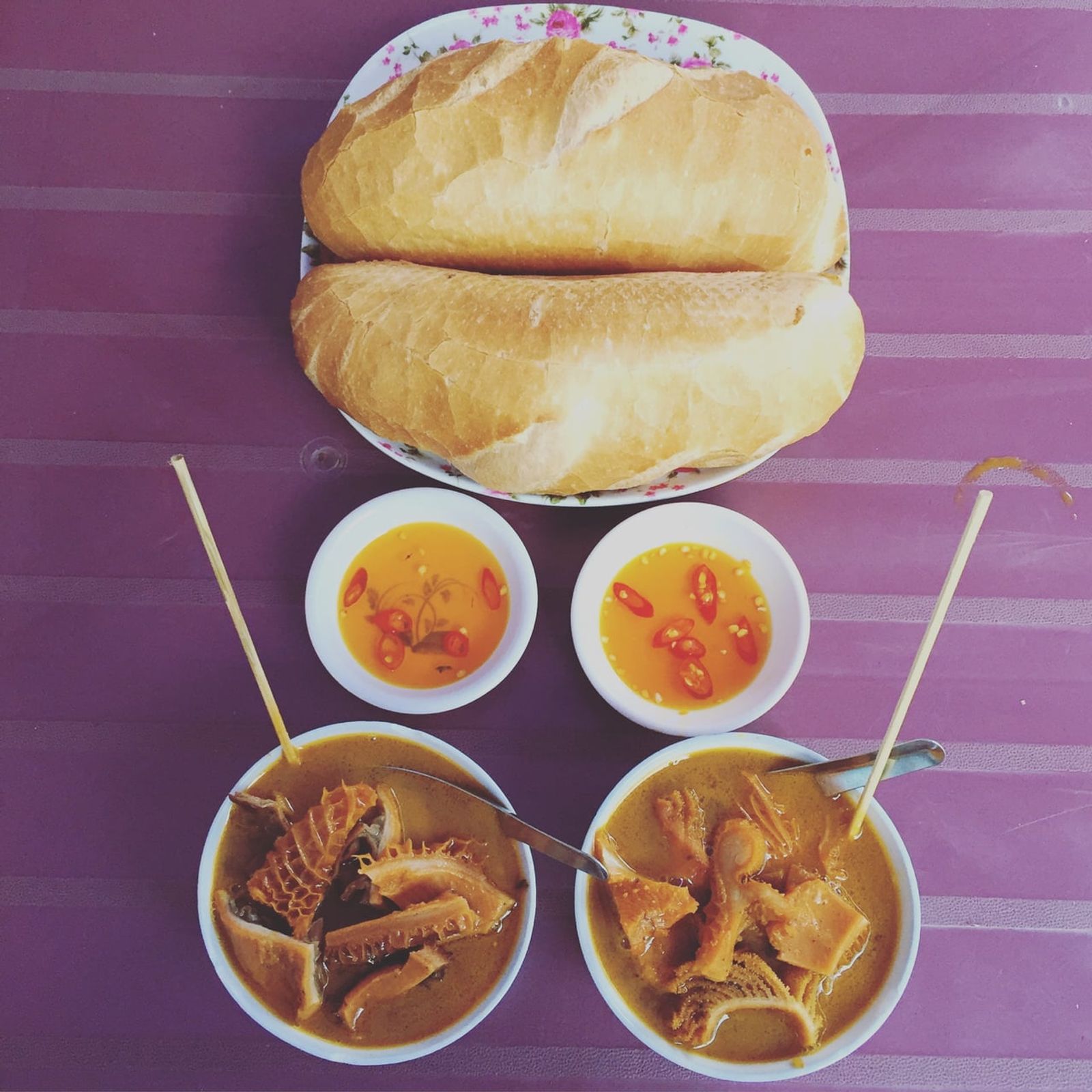 Two bowls of phá lấu served with baguettes · Photo: Policyandinternet / CC BY-SA 4.0 (Wikimedia Commons)
