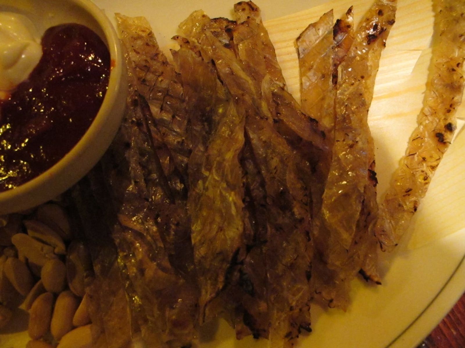 Grilled jwipo with a dipping sauce · Photo: Lisa Risager / CC BY-SA 2.0 (Wikimedia Commons)