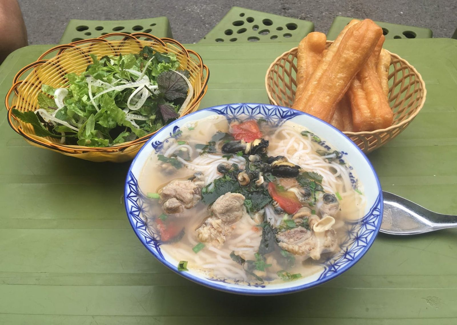 ハノイの路上食堂の麺と香草かご、クワイ · 写真: Christophe95 / CC BY-SA 4.0 (Wikimedia Commons)