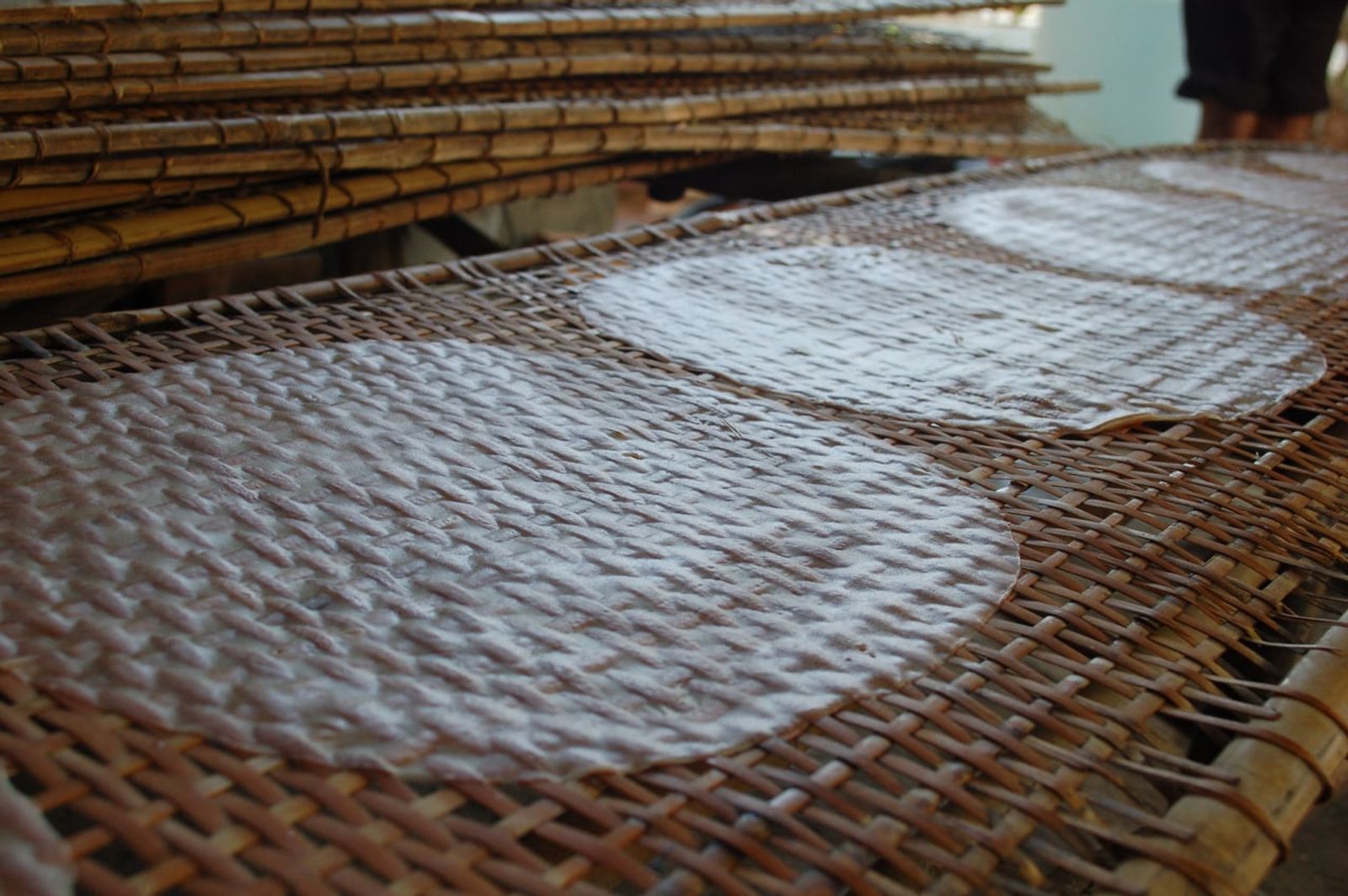 Handmade rice paper drying in the sun on bamboo mats · Photo: Wanderingspoon / CC BY-SA 4.0 (Wikimedia Commons)